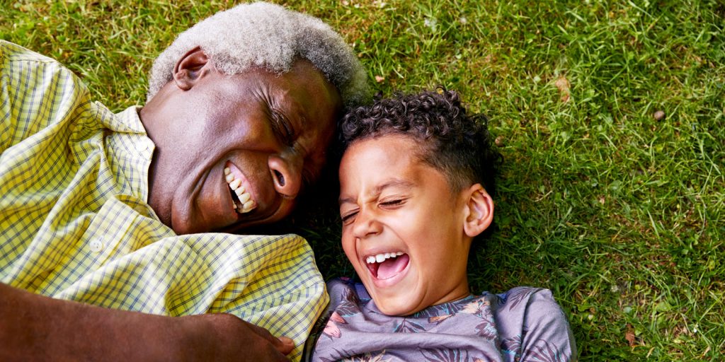 grandfather and grandson playing in grass