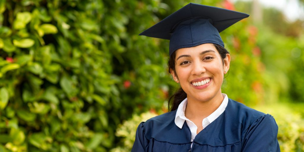 young women smiling in graduation cap and gown