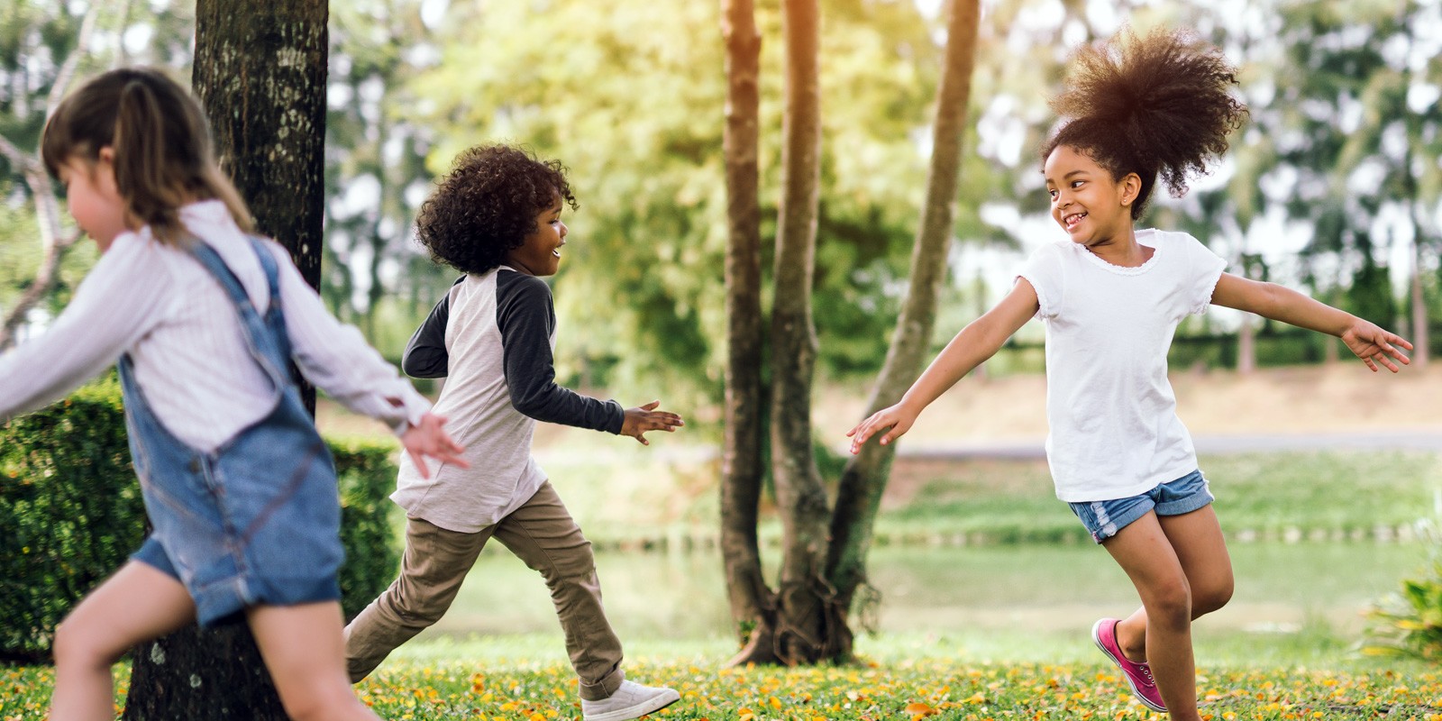 children outside playing around a tree