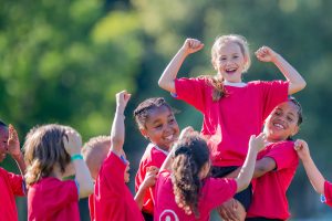 girls soccer team celebrating