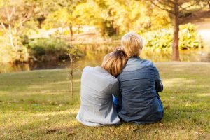 mother and adult daughter sit outside